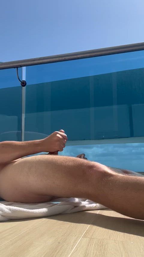 Ejaculating on the hotel balcony (visible from beach)