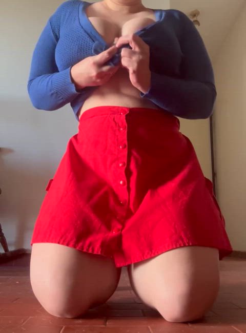 A soft little doll in blue and red, kneeling just to tease and let your imagination do the rest