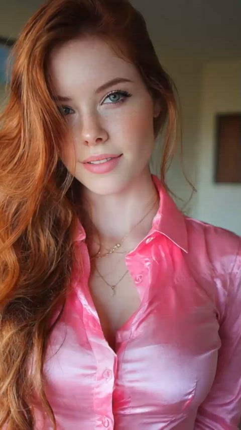 A beautiful redhead wearing a bright pink shirt