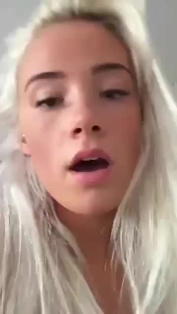 A blonde attractive woman is naked and having the sex from behind with presumably a man's penis via penetration to her vagina, all the while recording the scene with her cellular device. She is breathing rhythmically as the sound of the presumable man's testicles hits her labia major.