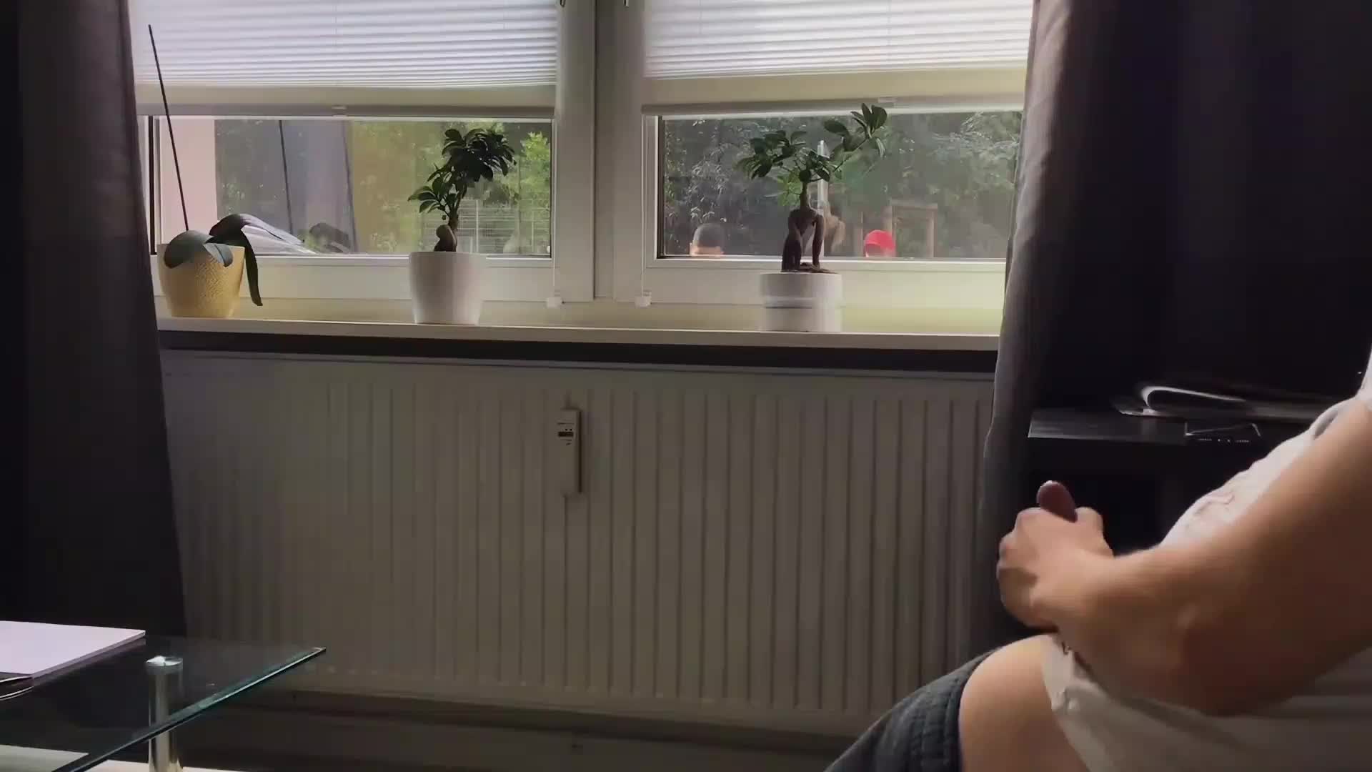 Exhibitionist jerks off in front of the window to an unsuspecting audience.