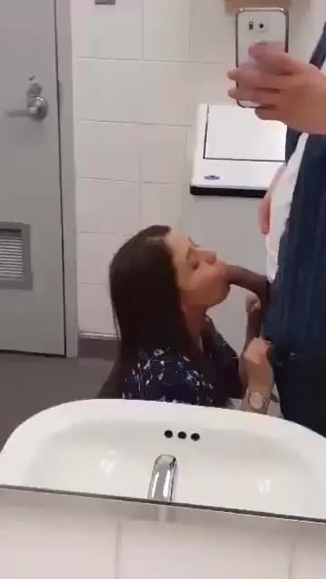 Secretary giving her boss a blowjob in the bathroom