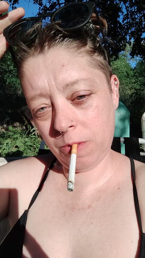 In the sun, blowing smoke