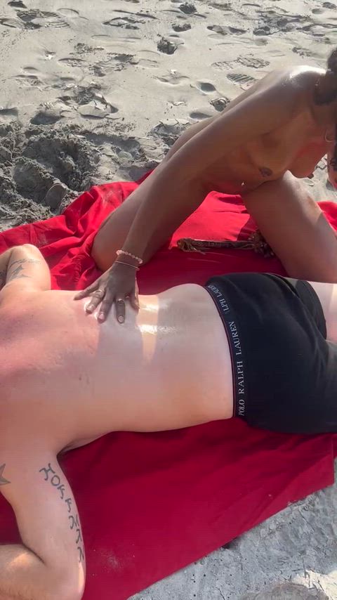 Hot wife giving a message nude to a fan in a public beach