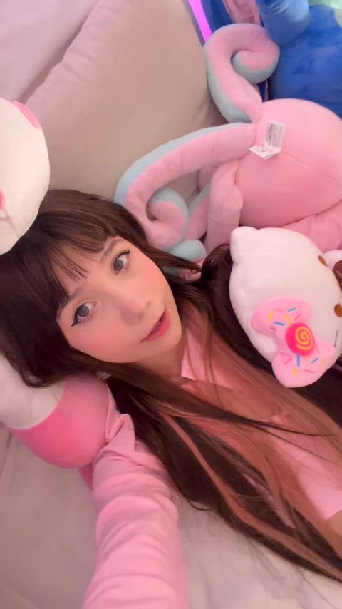 Cute kawaii girl smiling playfully with plushies, wanna pin me down daddy?